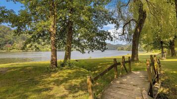 A wooden boardwalk leading to a lake surrounded by trees.