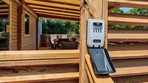 A wooden pergola structure with a built-in electrical outlet. - Bungalow Privas (AZALÉE (Unknown)