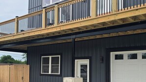 Un bâtiment à deux étages doté d’un balcon, d’un garage et d’un pilier en béton.