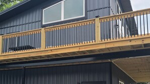 Un bâtiment à deux étages doté d’un balcon, d’un patio couvert et de mobilier d’extérieur.