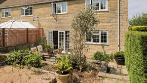 A two-story house with a garden in front. - Lorien (Cheltenham)