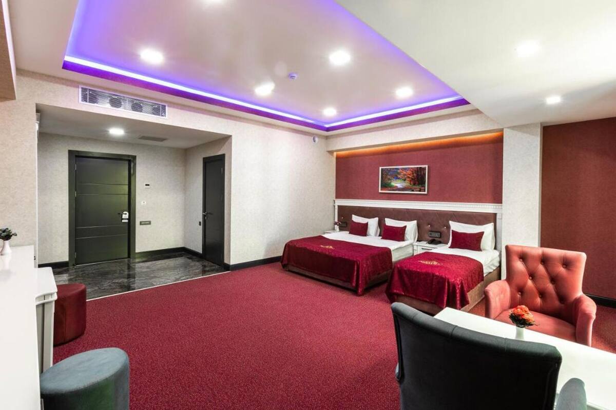 Habitación de hotel con dos camas, un escritorio y una silla.