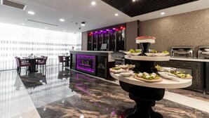 Un moderno vestíbulo de hotel con una zona de bar, un comedor y una recepción.