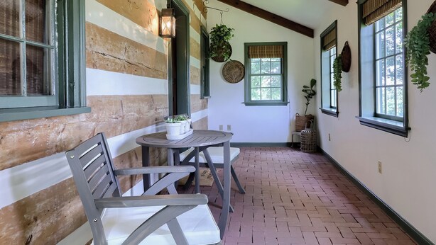 A rustic wooden cabin with a brick floor, a wooden bench, and a table with chairs. - Highville Hideaway - 2 bed, 1 bath, country views (Conestoga)