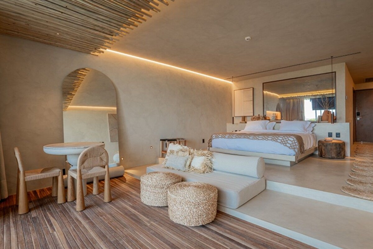 Una camera da letto moderna con un letto grande, una scrivania e un’area salotto.
