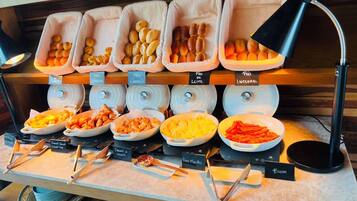 A buffet with labeled food containers and utensils.