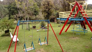 Une aire de jeux avec des balançoires et des structures d’escalade.