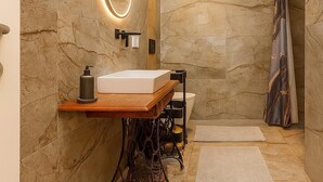 A modern bathroom with a marble wall, a wooden vanity, a large mirror, and a skylight. - Country House Dream under Walnut Trees (Nuthetal)