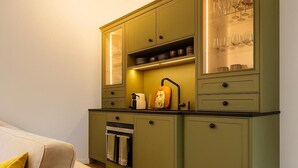 A compact kitchen with green cabinets, a built-in oven, and a coffee maker. - Country House Dream under Walnut Trees (Nuthetal)