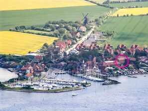 A coastal village with a marina, windmill, and houses with red roofs. - Bright Stuuv – Comfortable Living with Sunny Terrace and Fireplace (Fehmarn)