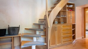 Un escalier en bois doté d’étagères intégrées et d’un meuble de rangement.