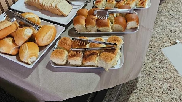 Ein Buffet mit verschiedenen Speisen, darunter Brot, Gebäck und Desserts.