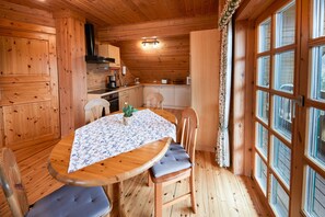 Un intérieur en bois avec une table ronde, des chaises et une fenêtre.