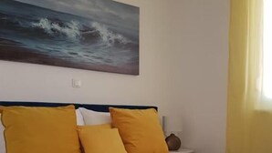 A bed with a blue bedspread and three mustard-colored pillows. - Apartment Nina - panoramic sea views (Slatine)