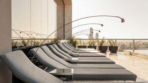 A row of sun loungers on a rooftop terrace with potted plants and a city view. - Impresionante Depto en Buenos Aires D907 (Buenos Aires)