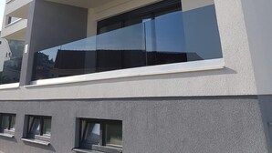 A modern multi-story building with balconies, large windows, and a clean architectural design. - Vlads' Place - pool & garden-view (Slatine)