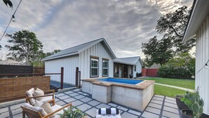 Patio con piscina, terraza de madera, mobiliario exterior y un cobertizo pequeño.