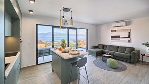 A modern living space with a kitchen, dining area, and seating area. - Imola‘s Place - Sea-View & Pool (Slatine)