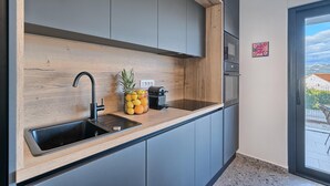 Une cuisine moderne avec un plan de travail en bois, un évier noir et une machine à café.