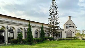 A large, white building with arched windows and a sign reading "Golden Town Pattaya Tai-Sukhumvit." - Minimalist Townhome Stay (Pattaya)