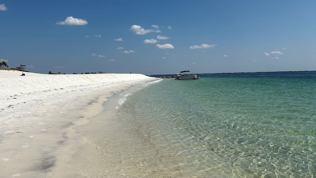 A beach with clear shallow waters, a boat on the water, and a sandy shore. - 3B/2B house with POOL. 700' to public boat ramp & .6 mi to beach access! (Panama City Beach)