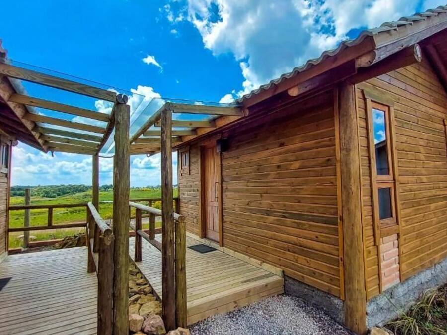 A wooden cabin with a wooden deck and a covered porch.