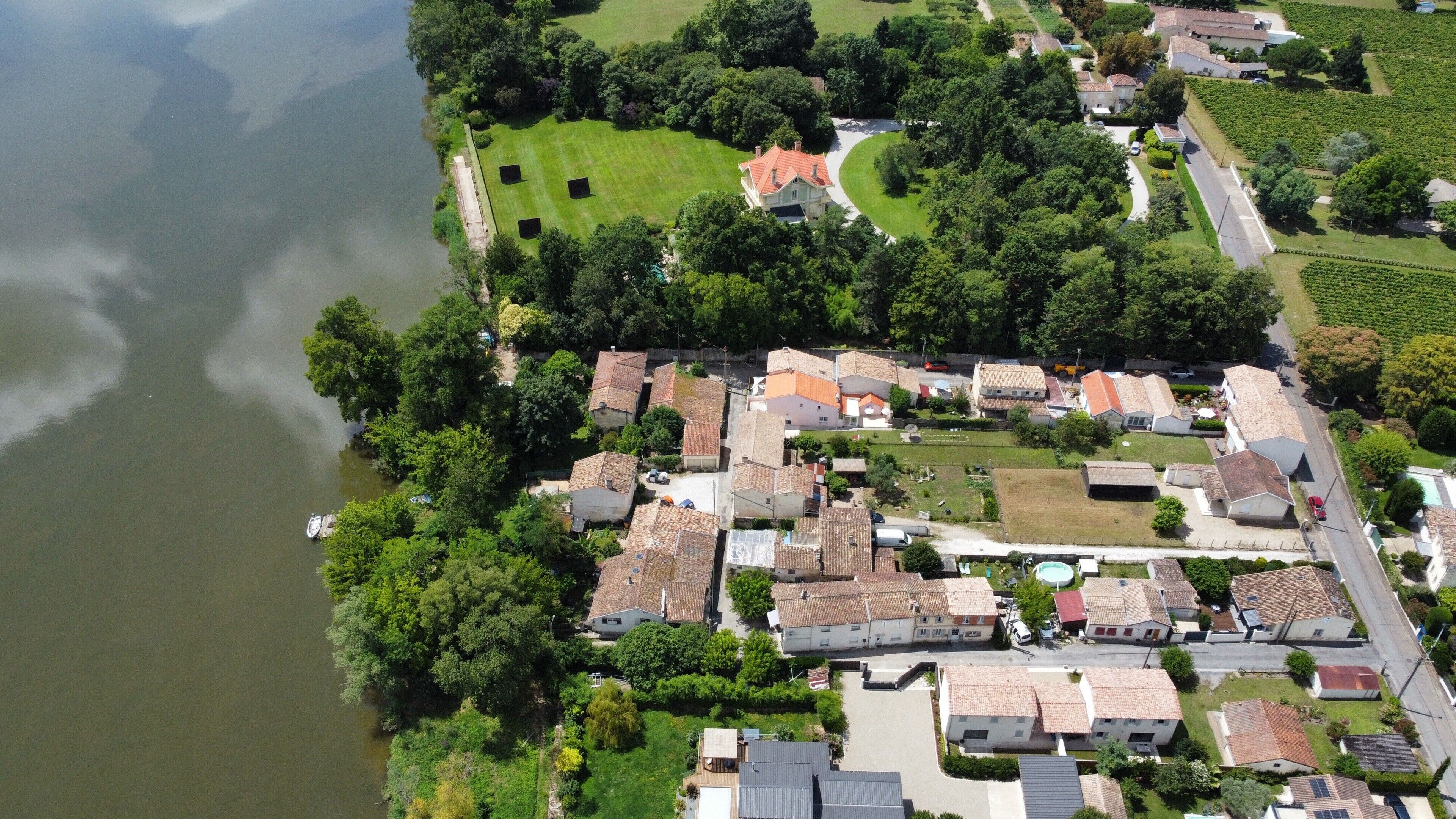 An aerial view of a residential area with houses, a lake, and a golf course.