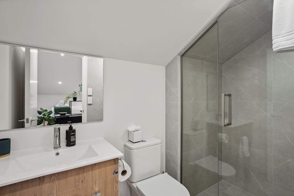 Modern bathroom with walk-in shower and fresh amenities