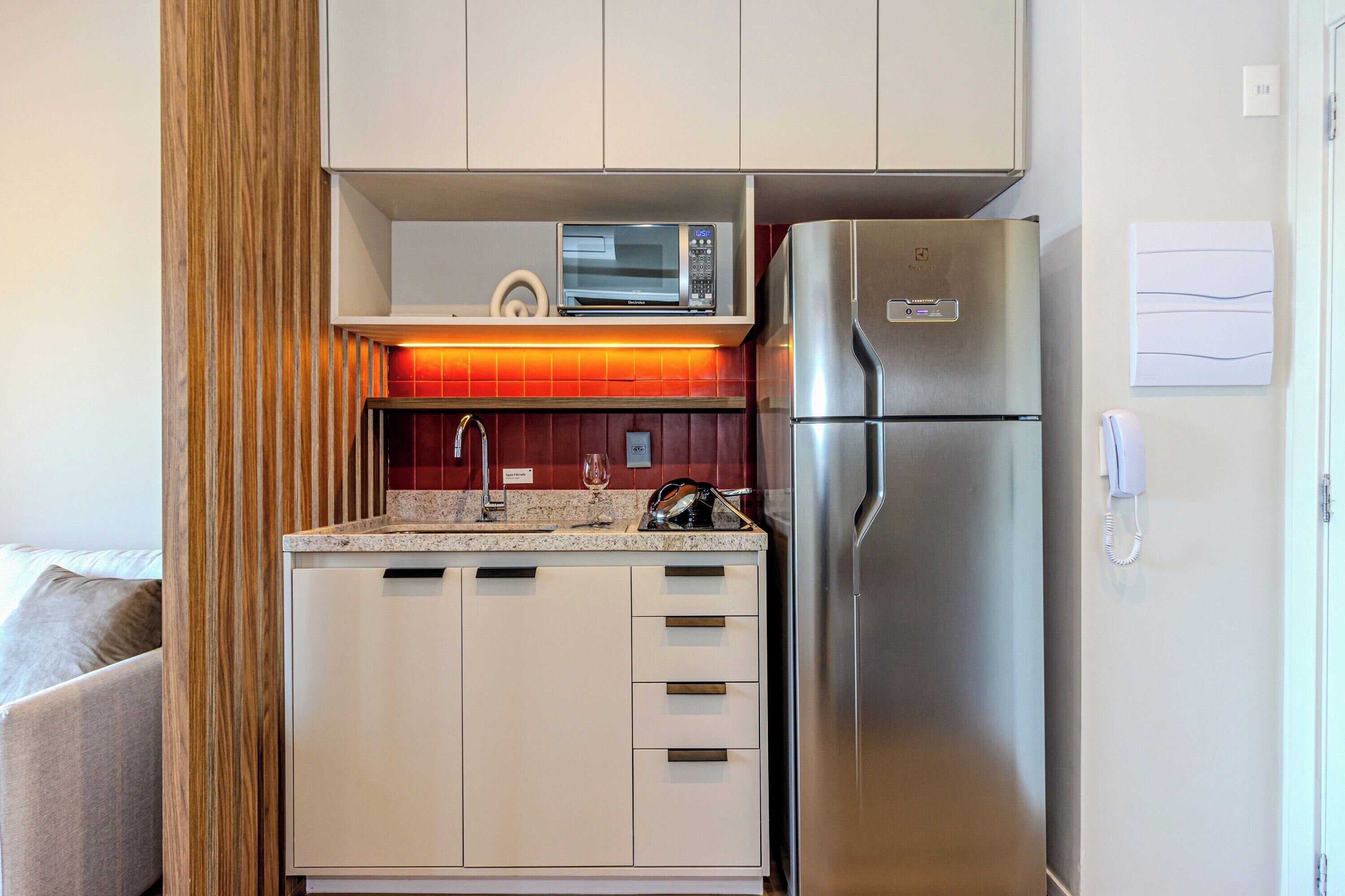 A compact kitchen with a microwave, refrigerator, and a small countertop.
