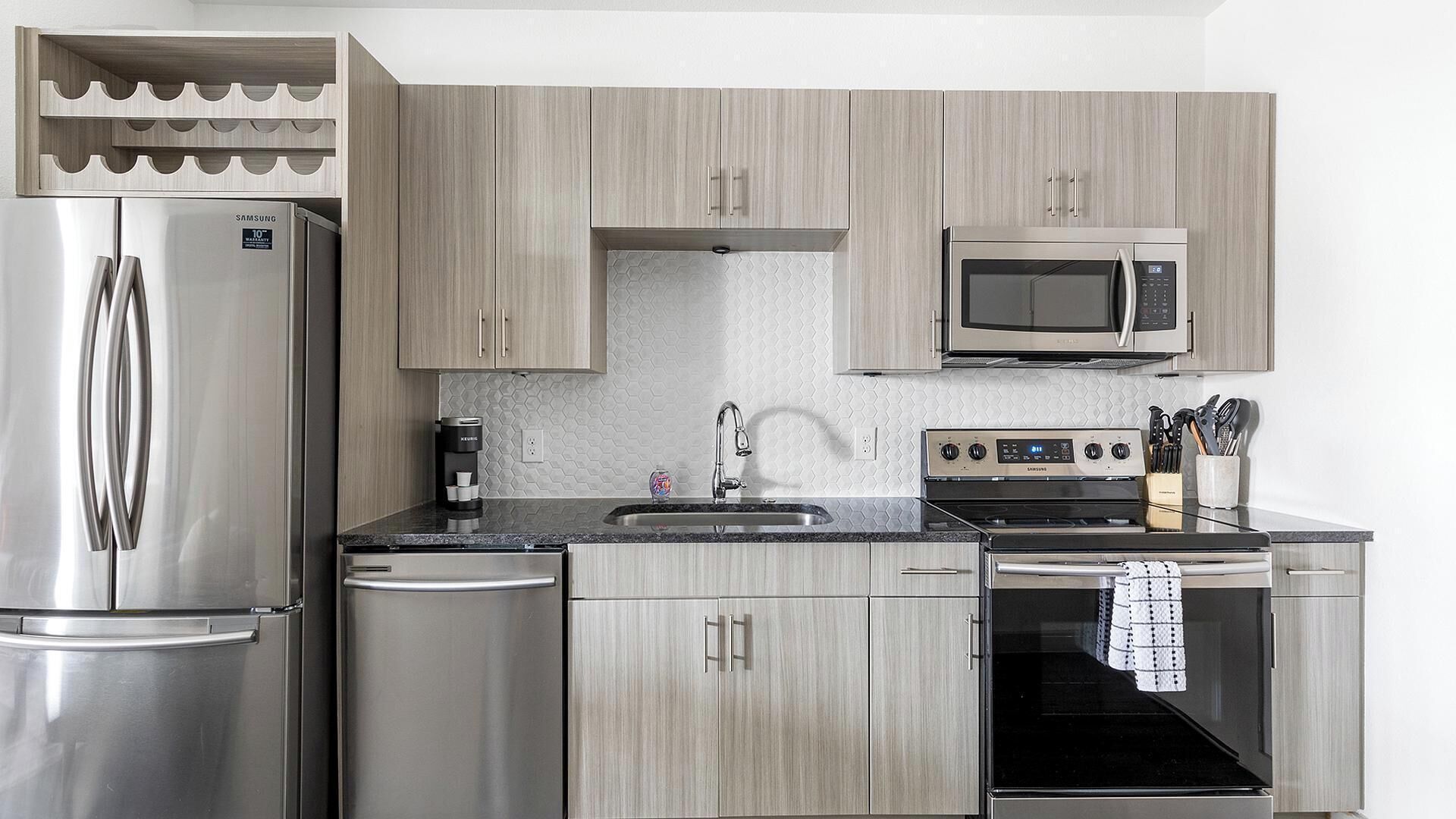 A modern kitchen with stainless steel appliances, a microwave, and a coffee maker.