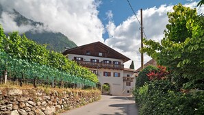 A mountain lodge with a stone wall, a wooden balcony, and a clear sky.