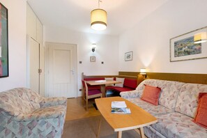 A room with a sofa, a table, a bench, and a bed.