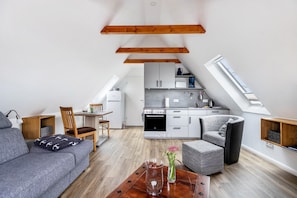 Un appartement de style « loft » comprenant une cuisine, un coin repas et un espace de vie.