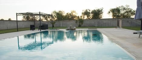 Una piscina al aire libre de temporada, sombrillas