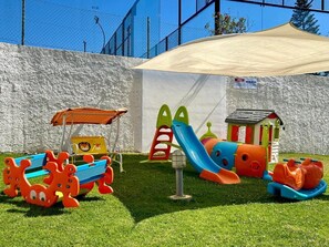 A children's play area with a slide, climbing structure, and a small house. - Apartment 'Santa Teresinha B' with Shared Pool, Wi-Fi and Air Conditioning (Alvor)