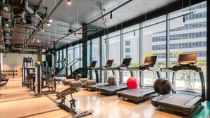 Una palestra con tapis roulant, palle da ginnastica e macchinari per pesi.