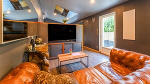 A modern living room with a leather sofa, a flat-screen TV, and a glass coffee table.