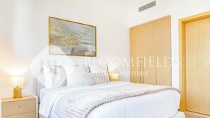 Ein Schlafzimmer mit Bett, Nachttischen, einem Kleiderschrank und einem Bild an der Wand.