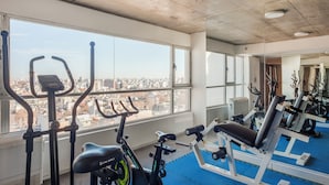 A gym with exercise equipment, large windows, and a city view. - Nicaragua Hollywood Suites & Lofts by Argenhost (Buenos Aires)