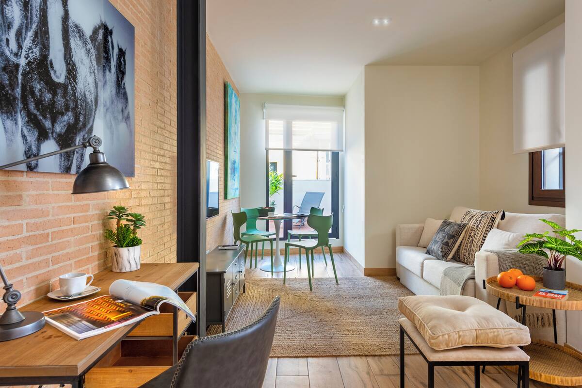 A modern living room with a sofa, coffee table, and a dining area with chairs and a table.