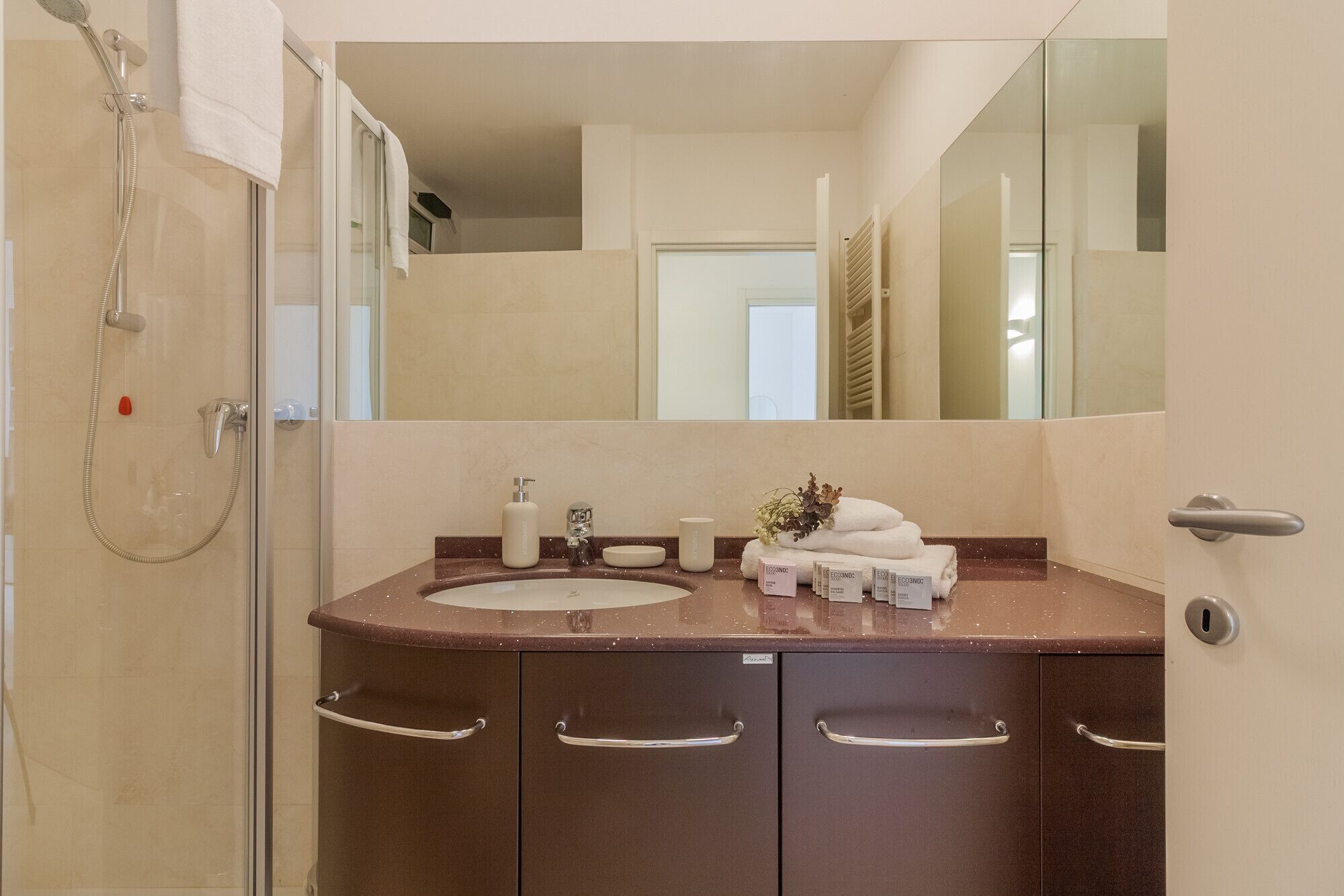 A bathroom with a shower, a sink, and a mirror.