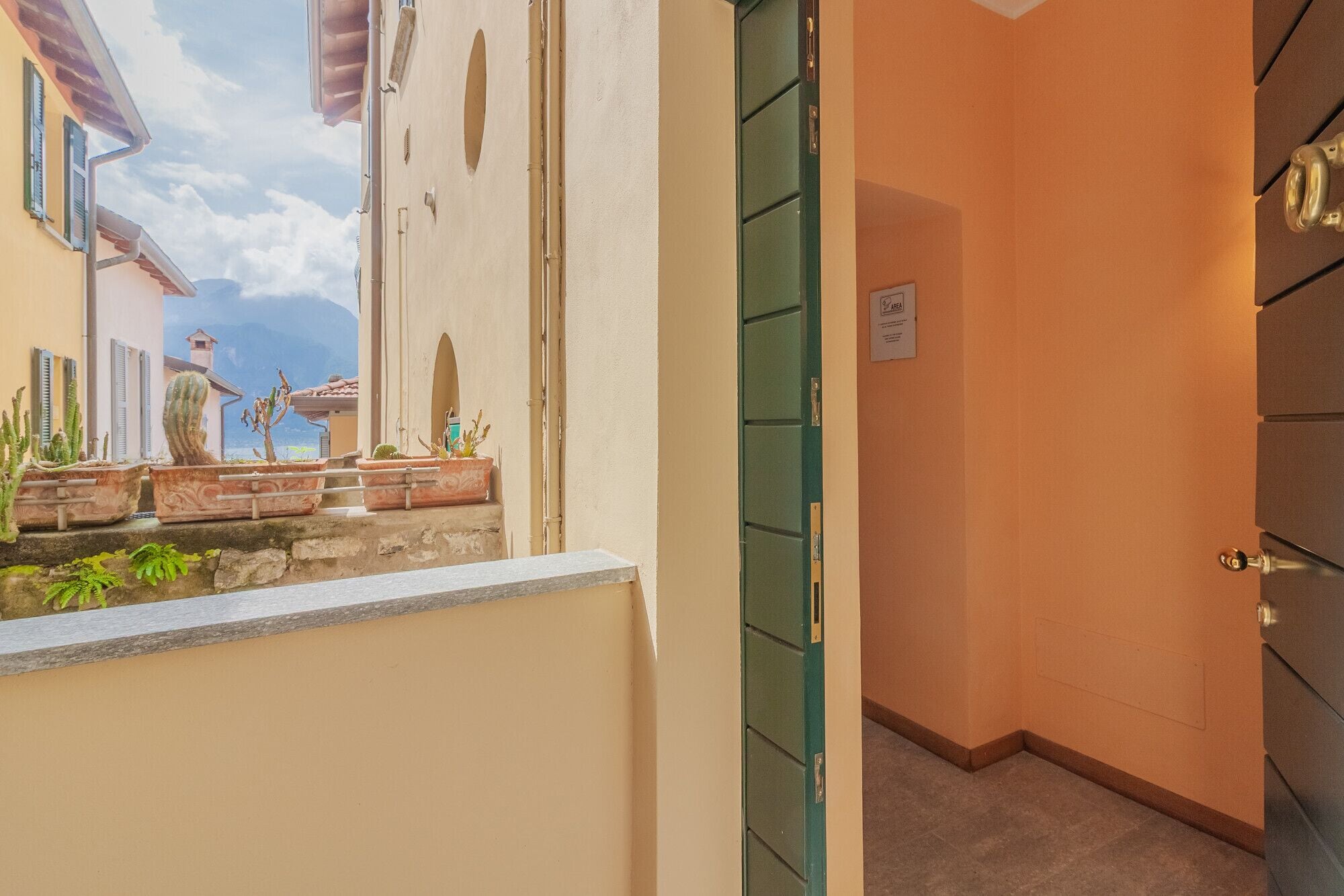 A narrow hallway with a green door and a small window.