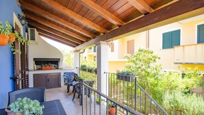 An outdoor patio with a wooden pergola, a grill, and seating. - Sa Sterlizia by All4sardinia  (Cardedu)