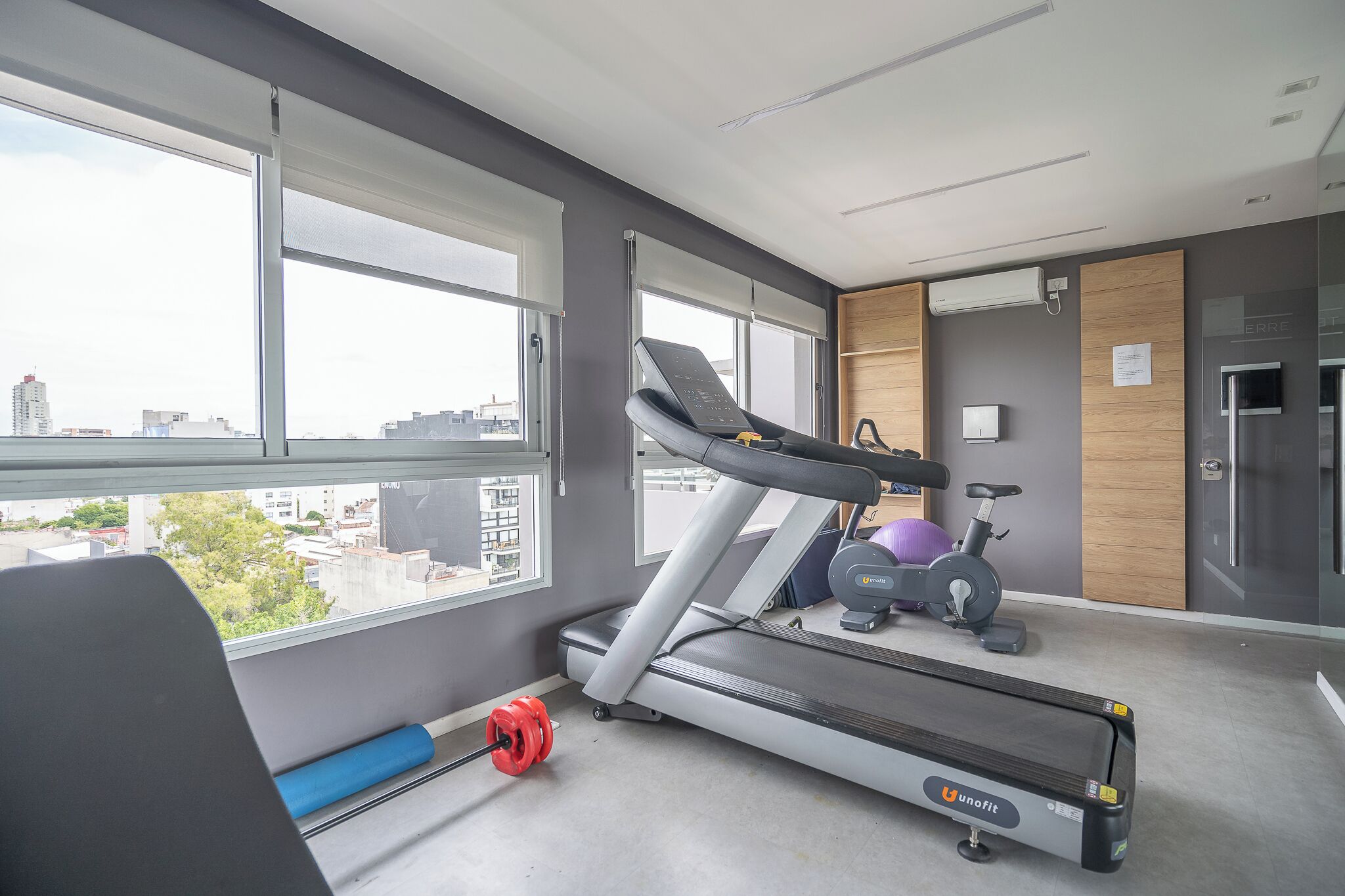 Ein modernes Fitnessstudio mit Laufband, Ergometer und Gewichten.