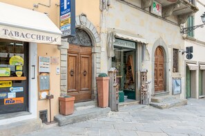 Ein Gebäude mit einer Holztür, einem Schild für 'Tabacccheria' und einem Laden namens 'Officina Verde'.