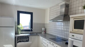 A modern kitchen with white cabinets, a stainless steel sink, a built-in dishwasher, and a double oven. - Villa Horizon Salobre 7 (San Bartolomé de Tirajana)