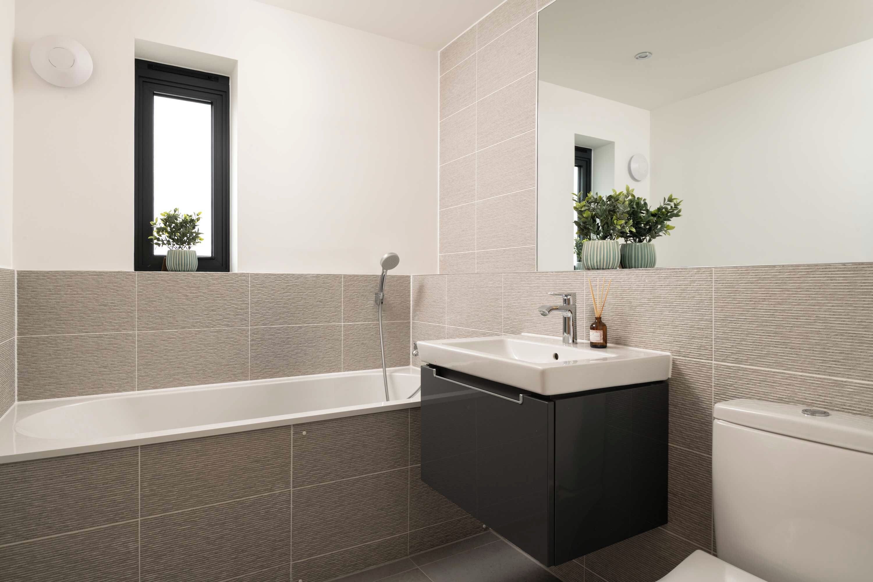 Une salle de bain moderne avec une baignoire sur pieds, un meuble-lavabo et des toilettes.