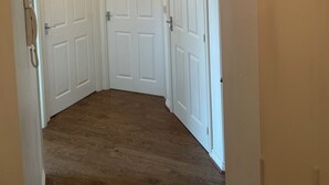 A hallway with two white doors, a ceiling light, and a telephone.
