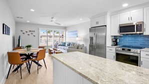 A modern kitchen with white cabinets, stainless steel appliances, and a granite countertop. - Updated Condo with Beach Access! Shared Pools, BBQ Area! Jamaica Royale Unit 053 (Siesta Key)