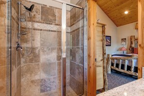 A shower with a glass door, a wooden ceiling, and a bed with a rustic headboard. - Timber Wolf Lodge | KBM Resorts | Gas Fireplace, Common Hot Tubs, Near Canyons Village | 2 Units, 5 Bedrooms | ML-1343 (Park City)